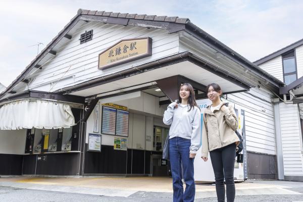 北鎌倉駅の前に立つ二人の女性の写真